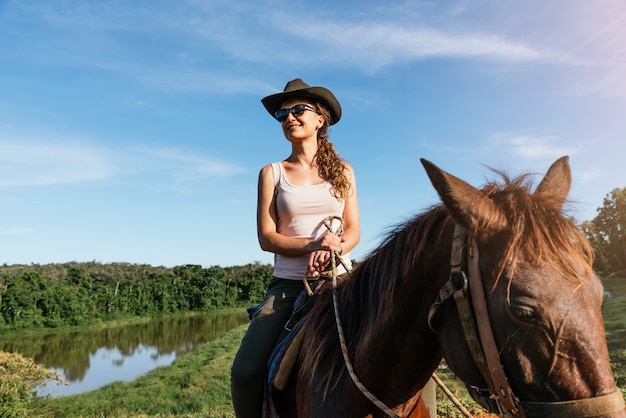 Hermosa mujer a caballo en el campo.