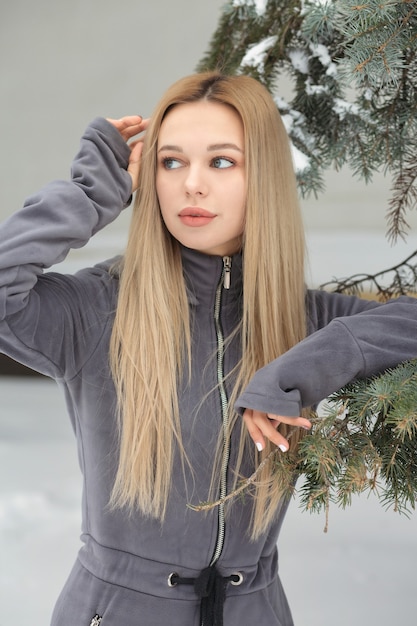 Hermosa mujer con cabello largo posando en el bosque en invierno