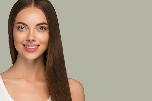 Hermosa mujer con cabello largo y saludable, belleza natural, estilo casual. Fondo de color verde