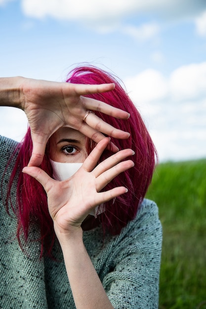 Foto hermosa mujer con cabello rosado en la naturaleza