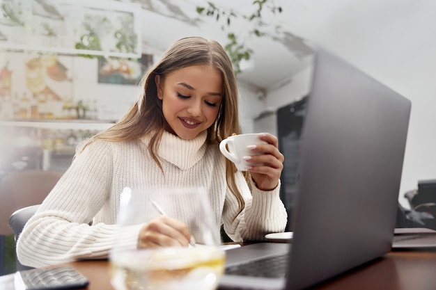 Hermosa mujer en un café tomando café y sonriendo