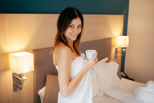 Hermosa mujer en la cama con café