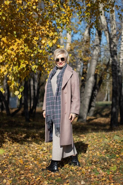 Hermosa mujer camina en el parque en otoño. Foto de alta calidad