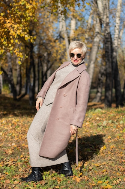 Hermosa mujer camina en el parque en otoño. Foto de alta calidad