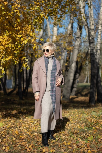 Hermosa mujer camina en el parque en otoño