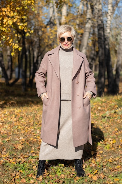 Hermosa mujer camina en el parque en otoño