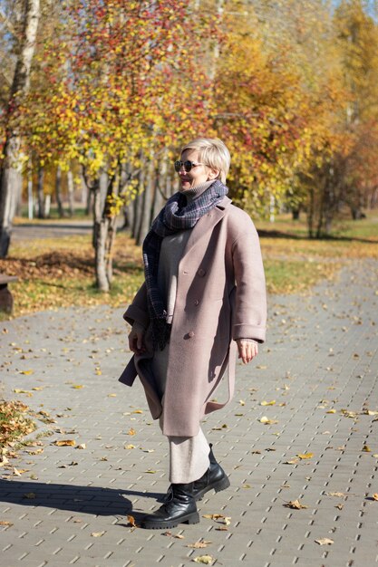 Hermosa mujer camina en el parque en otoño