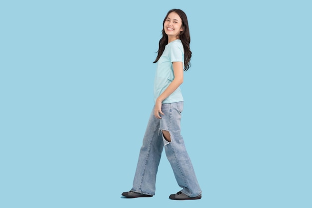 Hermosa mujer caminando sobre un fondo azul ella es feliz