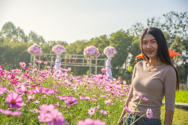 Hermosa mujer en un campo de flores cosmos