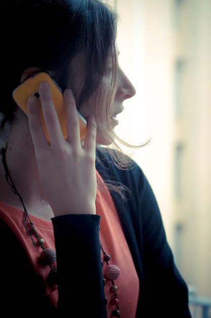 Foto hermosa mujer en casa en el teléfono