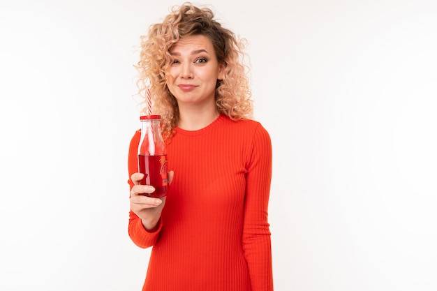 Hermosa mujer caucásica bebe jugo rojo