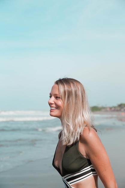 Hermosa mujer caucásica en bikini verde en la playa tropical Retrato de mujer joven feliz