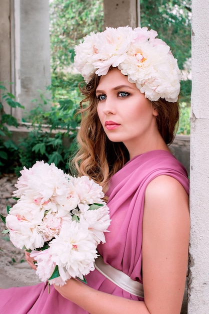 hermosa mujer caucásica con una corona de peonías en la cabeza Concepto de hada de flor de primavera