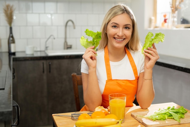 Hermosa mujer caucásica en un delantal cocinando en la cocina