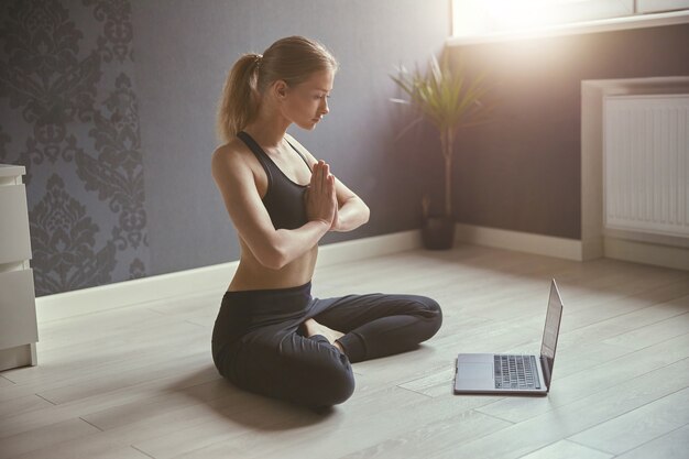 Hermosa mujer caucásica haciendo deporte en el acogedor apartamento