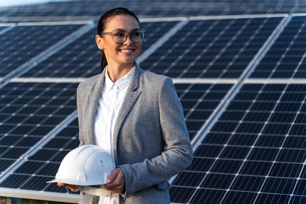 Hermosa mujer caucásica ingeniera en la granja de baterías de energía solar