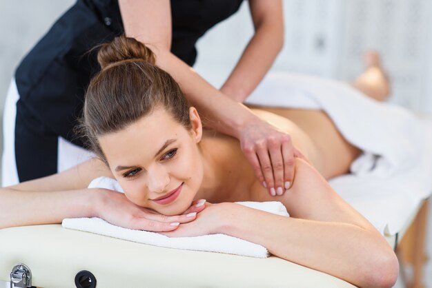 Hermosa mujer caucásica durante el masaje en el salón de spa.