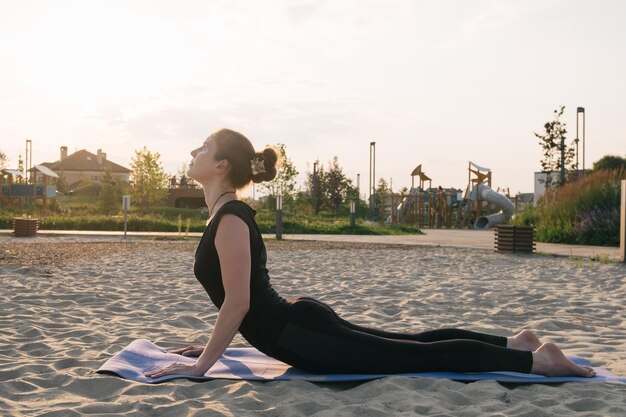 Foto hermosa mujer caucásica practicando yoga en un parque de la ciudad