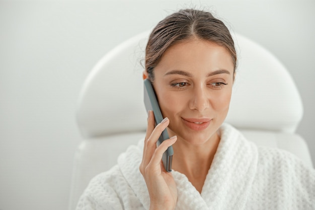 Hermosa mujer caucásica sonriente sana está haciendo procedimientos de belleza en el spa y salón de salud