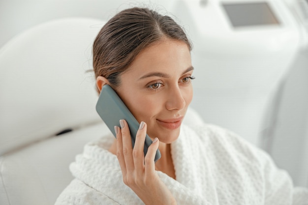 Hermosa mujer caucásica sonriente sana está haciendo procedimientos de belleza en el spa y salón de salud