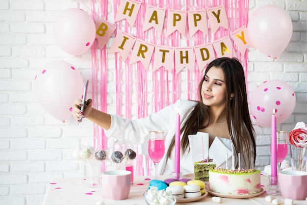 Foto hermosa mujer celebrando la fiesta de cumpleaños tomando selfie