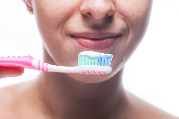 Hermosa mujer cepillando sus dientes de cerca. Tratamientos matutinos