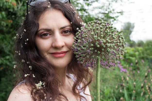 Hermosa mujer cerca de las plantas en el jardín de verano