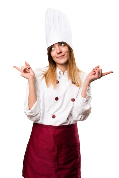 Foto hermosa mujer chef apuntando a los laterales con dudas