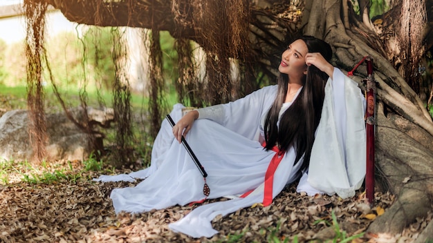 Hermosa mujer china con un traje tradicional con una flauta en sus manos.