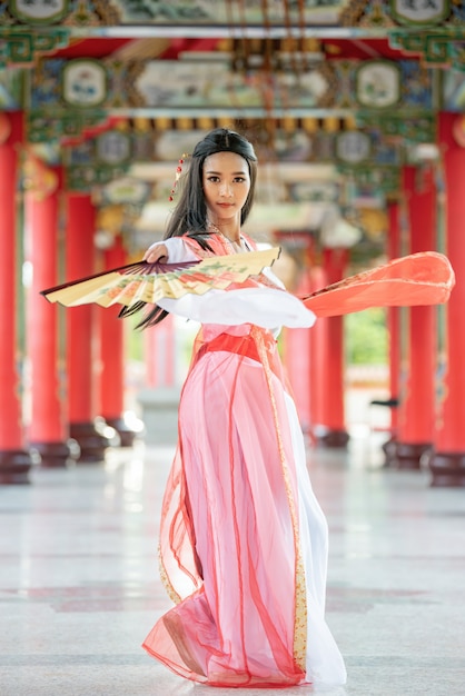 Foto hermosa mujer china con un traje tradicional con golpe en sus manos.