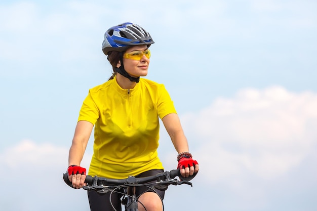 Hermosa mujer ciclista con ropa amarilla en la bicicleta, pasatiempos deportivos y entretenimiento para la salud.