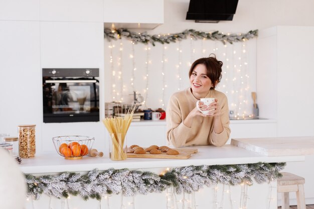 Hermosa mujer en la cocina en Navidad