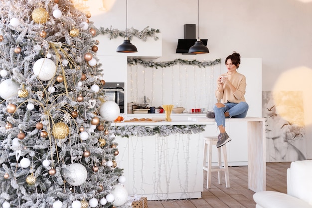 Hermosa mujer en la cocina en Navidad