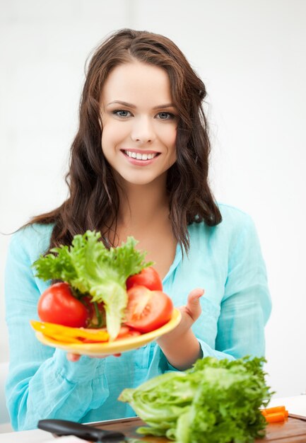 hermosa mujer en la cocina con verduras