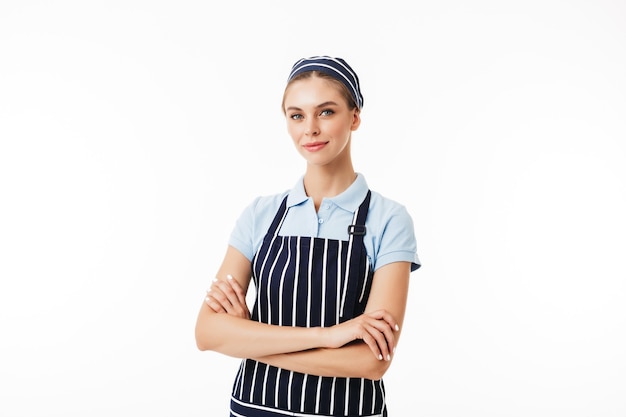 Hermosa mujer cocinera en delantal a rayas y gorra soñadora