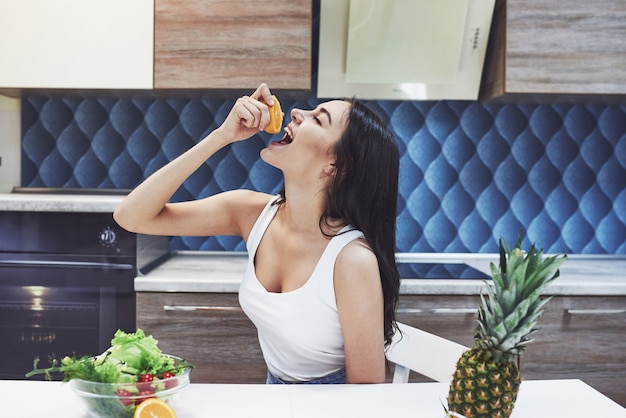 Hermosa mujer con comida sana fruta en la cocina