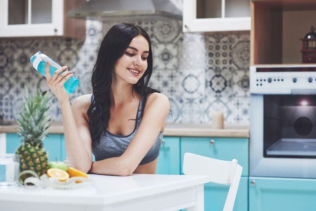 Hermosa mujer con comida sana fruta en la cocina