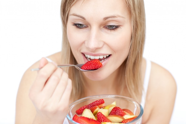 Hermosa mujer comiendo una ensalada de frutas