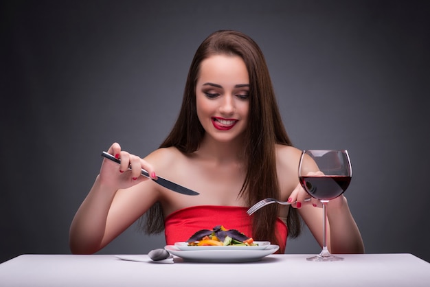 Hermosa mujer comiendo sola con vino