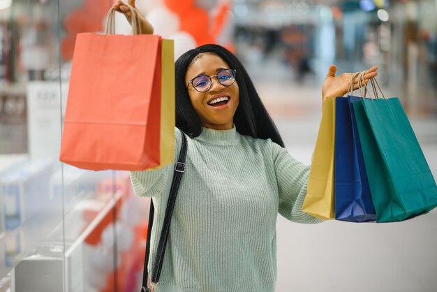 Hermosa mujer de compras sonriendo y sosteniendo bolsas