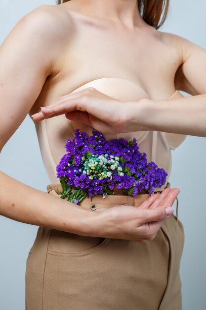 Hermosa mujer confiada sosteniendo flores frescas de primavera en sus manos Flores frescas en manos de una mujer rubia