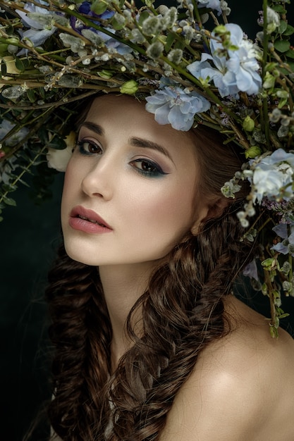 Hermosa mujer con una corona de flores en la cabeza. Hada del bosque