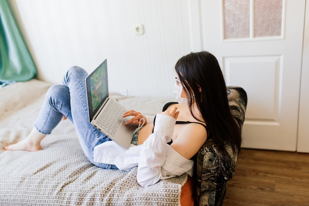 Hermosa mujer en cuarentena con máscara protectora y trabajando en casa