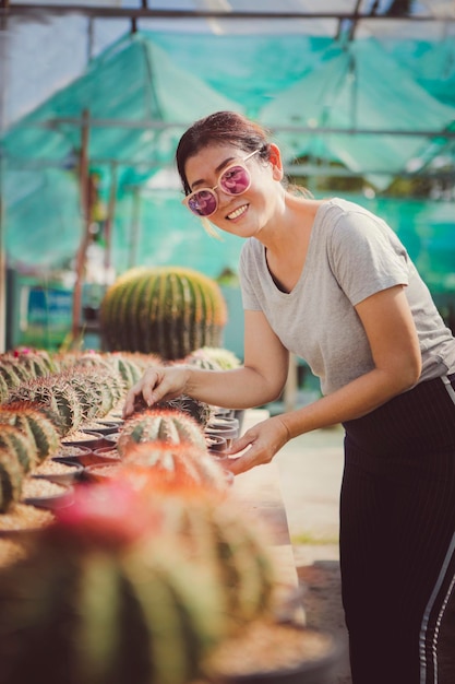 Hermosa mujer cuidando cactus en suculenta casa verde