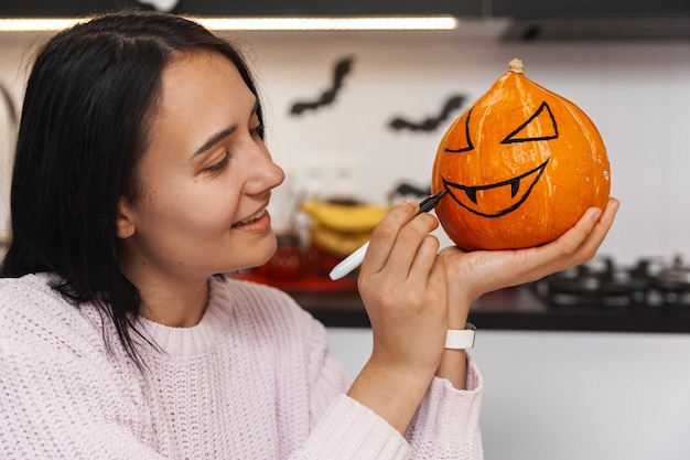 Hermosa mujer decorando calabaza para fotos de primer plano de Halloween