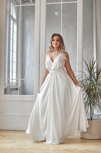 Hermosa mujer delgada en vestido de novia blanco, nueva colección de vestidos para la novia