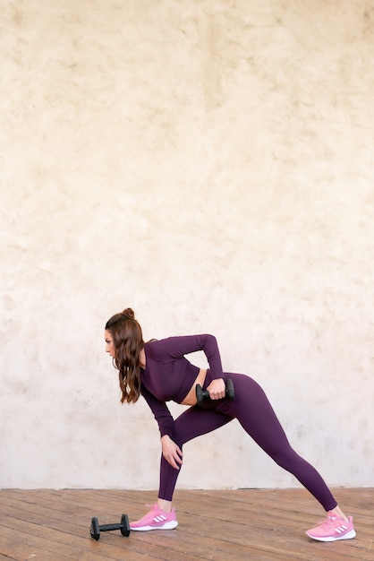 Hermosa mujer deportiva haciendo entrenamiento de fuerza fitness funciona con pesas