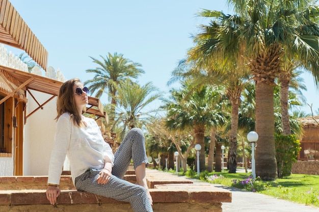 Hermosa mujer descalza en relajarse bajo el sol de vacaciones en un día soleado en el resort