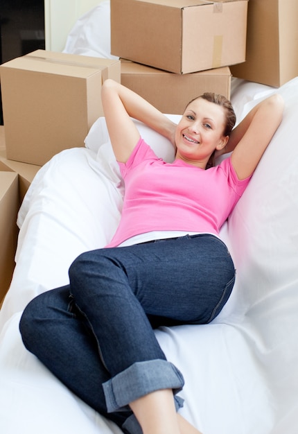 Hermosa mujer descansando en un sofá con cajas