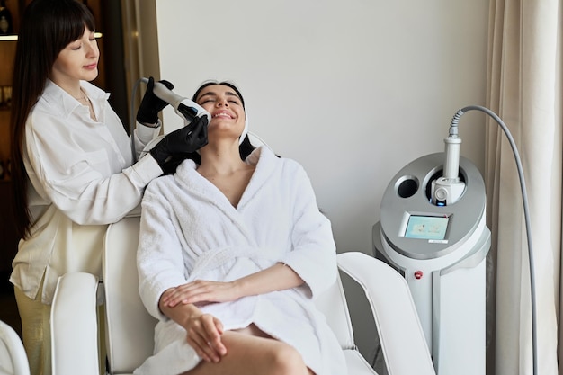 Hermosa mujer disfruta de un masaje de glúteos con una máquina de endoesfera para la corrección anticelulítica y corporal